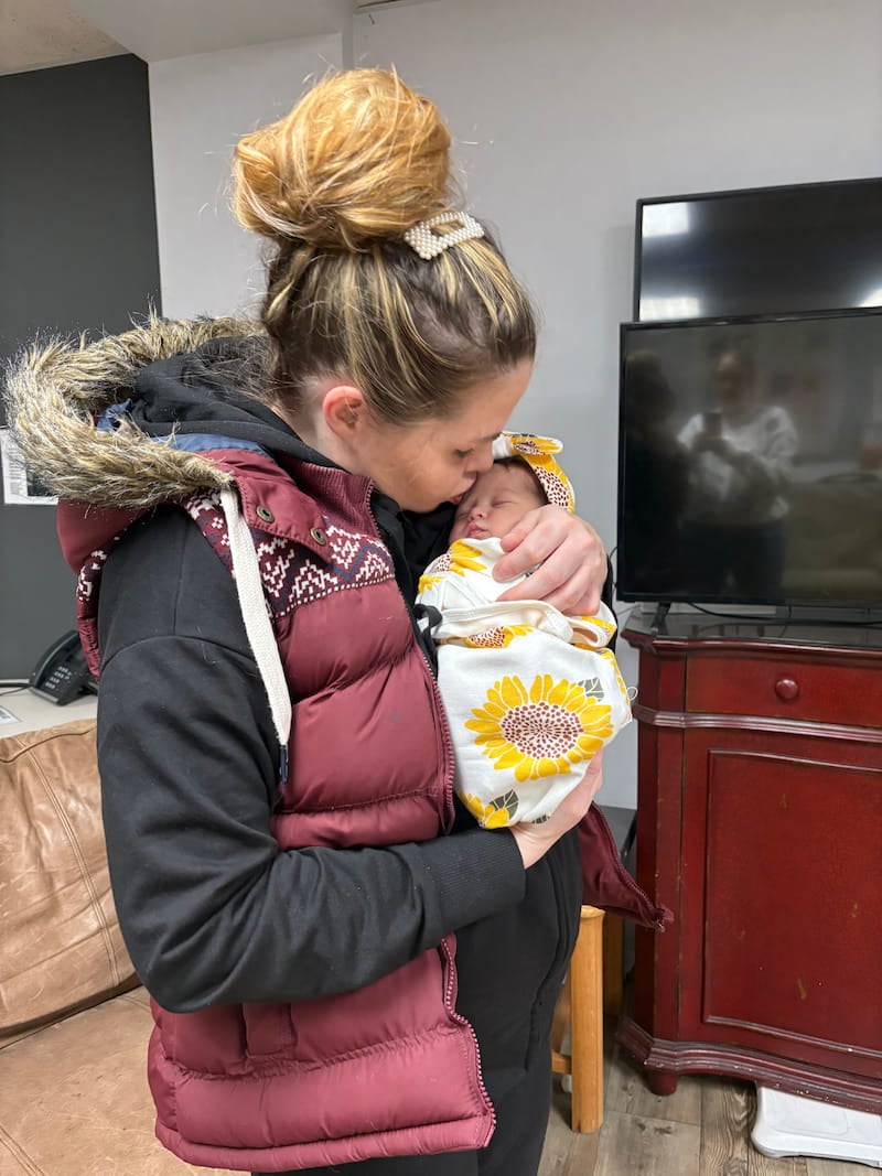 mother kissing new born child at the transitional living center